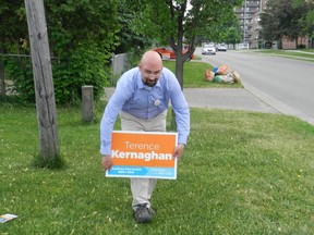London North Centre NDP candidate Terence Kernaghan plants a sign on the lawn of a supporter on Briarhill Avenue. (HAND DANISZEWSKI, The London Free Press)