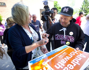 Longtime liberal supporter Randy Dewael of Chatham gets Andrea Horwath to autograph his election sign during a campaign stop in Chatham on Monday.  Mike Hensen/The London Free Press/Postmedia Network