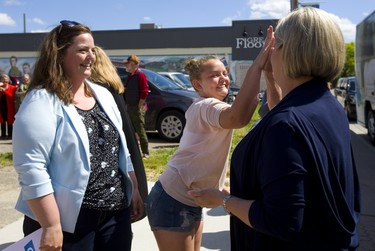 NDP leader Andrea Horwath gets an enthusiastic high five from Marissa McCutcheon, 11 the daughter of Elgin-Middlesex-London NDP candidate Amanda Stratton during a St. Thomas campaign stop on Monday. Mike Hensen/The London Free Press/Postmedia Network
