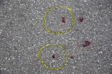 Blood stains the parking area in front of unit 47 at 1443 Huron Street.  A man was shot in the hand/wrist with a shotgun after an intruder gained entry by shooting the door handle off the back door. (Derek Ruttan/The London Free Press)