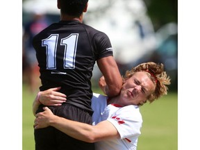 Alistair Wotherspoon of the Medway Cowboys gets a bit of an elbow from Oakville Trafalgar's Andrew DeSousa during their semifinal at the St. George's Rugby fields on Friday. Medway won and went on to claim OFSAA's AAA boys rugby gold on Saturday. Mike Hensen/The London Free Press/Postmedia Network