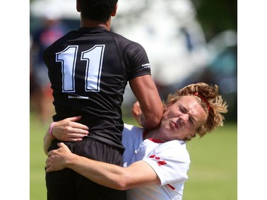 Alistair Wotherspoon of the Cowboys gets a bit of an elbow from Oakville Trafalgar's Andrew DeSousa during their semifinal at the St. George's Rugby fields on Friday. The Medway Cowboys punched their ticket for the gold medal game at OFSAA's AAA boys rugby by beating Oakville Trafalgar 20-0 on Friday in the semi's to get the chance at Brantford's St. John's College.  Mike Hensen/The London Free Press/Postmedia Network
