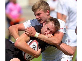 Ian Bennett of the Medway Cowboys stops the run of Oakville Trafalgar’s Andrew Easson during their OFSAA AAA boys rugby semifinal at the St. George’s fields on Friday. The Cowboys punched their ticket for the gold medal game by winning 20-0.  (Mike Hensen/The London Free Press)