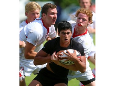 Trevor Sims and Collin Smibert of the Cowboys try to corral the speed of Oakville Trafalgar's Andrew DeSouza during their semifinal at the St. George's Rugby fields on Friday. The Medway Cowboys punched their ticket for the gold medal game at OFSAA's AAA boys rugby by beating Oakville Trafalgar 20-0 on Friday in the semi's to get the chance at Brantford's St. John's College.  Mike Hensen/The London Free Press/Postmedia Network
