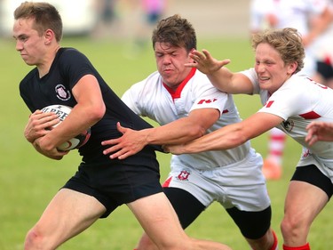 Liam McDonald and Devon Ollson of the Cowboys combine to slow down Oakville Trafalgar's Andrew Easson during their semifinal at the St. George's Rugby fields on Friday. The Medway Cowboys punched their ticket for the gold medal game at OFSAA's AAA boys rugby by beating Oakville Trafalgar 20-0 on Friday in the semi's to get the chance at Brantford's St. John's College.  Mike Hensen/The London Free Press/Postmedia Network