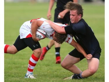 Nathan Campbell of the Cowboys is tackled by Oakville Trafalgar's Sam Hibbert during their semifinal at the St. George's Rugby fields on Friday. The Medway Cowboys punched their ticket for the gold medal game at OFSAA's AAA boys rugby by beating Oakville Trafalgar 20-0 on Friday in the semi's to get the chance at Brantford's St. John's College.  Mike Hensen/The London Free Press/Postmedia Network