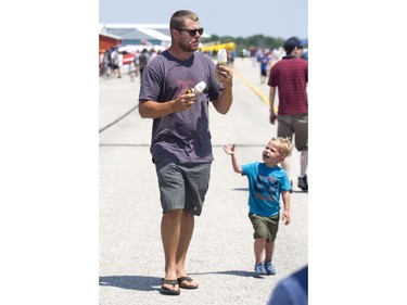 Almost three-year-old, Liam Friessen offers to help his dad,  Dietrich, carry ice cream cones Sunday at the 2018 Great Lakes International Airshow  in St. Thomas. Laim might have gotten his cone sooner had he not been wearing a shirt stating "My mom is my superhero" on Father's Day. Derek Ruttan/The London Free Press