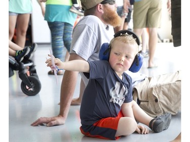 Almost three year old, Bryson Stacey plays with a toy airplane Sunday while attending the 2018 Great Lakes International Airshow with his father, Cale, in St. Thomas. Derek Ruttan/The London Free Press