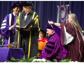 All 6 feet 4 inches of Eric Lindros has to kneel on stage at Alumni Hall to be hooded for his honorary doctorate on Monday, giving Western University president Amit Chakma, left, and chancellor Jack Cowin a good laugh. Mike Hensen/The London Free Press.