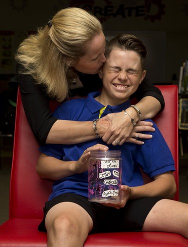 Thirteen-year-old Ashton Lefteris winces with embarrassment as he gets a kiss from his mom Jen Lefteris. Inspired by his mom's battle with breast cancer, Ashton has raised thousands of dollars for the London Health Sciences Centre in London, Ont. Photo taken on Tuesday June 19, 2018. Derek Ruttan/The London Free Press/Postmedia Network