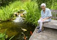 Yalonde McIntosh of Delaware shows off her pond with large koi, her gardens are part of the Lambeth Garden Tour.  Mike Hensen/The London Free Press/Postmedia Network