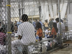 In this photo provided by U.S. Customs and Border Protection, people who've been taken into custody related to cases of illegal entry into the United States, sit in one of the cages at a facility in McAllen, Texas, on June 17. (U.S. Customs and Border Protection's Rio Grande Valley Sector via AP)