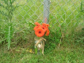 Flowers rest beside a rail side fence in Ingersoll in memory of the pedestrian killed Friday by a Via Rail passenger train. (Submitted photo)