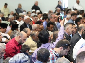A man records a video at the Islamic Centre of Southwest Ontario, where hundreds of worshippers gathered Friday to celebrate Eid al-Fit, the end of the holy month of Ramadan. DALE CARRUTHERS / THE LONDON FREE PRESS