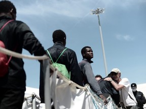 This photo released on Sunday by French NGO SOS Mediterranee, shows migrants disembarking the SOS Mediterranee's Aquarius ship and MSF (Doctors Without Borders) NGOs, after its arrival at the eastern port of Valencia, Spain. Ships in the Aquarius aid convoy docked Sunday at the Spanish port of Valencia, ending a week long ordeal for hundreds of people who were rescued from the perilous Mediterranean only to become the latest pawn in Europe's battle over immigration. (Kenny Karpov/SOS Mediterranee via AP)