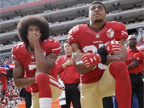 In this Oct. 2, 2016, file photo, San Francisco 49ers quarterback Colin Kaepernick, left, and safety Eric Reid kneel during the national anthem before an NFL football game against the Dallas Cowboys in Santa Clara, Calif.