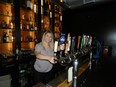 Michaela Botnick, a manager at The Pub on Richmond  pours a draught at the elegant bar at the rear of the new Richmond Row pub. (HANK DANISZEWSKI, The London Free Press)