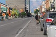 A cyclist rides around parked cars next to the bicycle lane at King and Talbot Streets. (SHALU MEHTA/THE LONDON FREE PRESS)