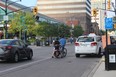 Two cyclists, one of them on an e-bike, make room and move to the left-hand side of a bike lane at King at Talbot Streets so a taxi could make a right turn. (SHALU MEHTA/THE LONDON FREE PRESS)