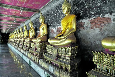 Buddha statues line the inside wall of Wat Suthat Thepwararam Ratchaworahawihan. The Bangkok temple houses the ashes of King Rama VIII. 
(Jennifer Bieman/The London Free Press)