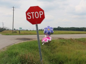 Two memorial flower balloons twirl in the wind around the stop sign at the intersection of Nairn Road and McEwan Drive, the location of a fatal two-vehicle collision on Monday. A seven-year-old girl died of her injuries and her mother is in hospital in critical, but stable condition. (SHANNON COULTER, The London Free Press)