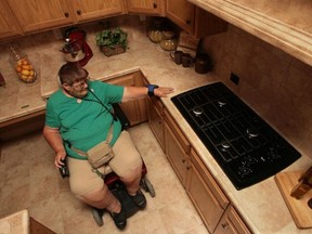 This kitchen  featuring 'Universal Design' features, with a lower counter section, behind her at left, wider doorways, better access to appliances and sinks, making it user-friendly for persons with disabilities. (Getty Images)
