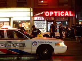 Toronto police officers walk the scene at Danforth Street at the scene of a shooting in Toronto, on July 23, 2018. A gunman opened fire in central Toronto on Sunday night, injuring 13 people including a child. Two dead incluiding gunman, police reported. (COLE BURSTON/AFP/Getty Images)