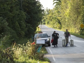 A cab drops off a couple of asylum seekers at the US/Canada border near Champlain, New York. Thousands of refugees streamed across the Canada/US, overwhelming the government's capacity to house them while their claims are processed.