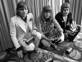 Members of the pioneering progressive rock band Emerson, Lake and Palmer -- Greg Lake, left, Keith Emerson, and Carl Palmer -- accept  an award in London, England in 1972 (PA file via AP)