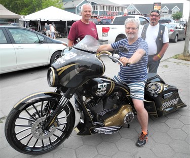 The Professional Hockey Players’ Association of Niagara Falls is raffling off this custom-built 2006 Harley-Davidson in support of several charities. The 2006 model is 10 feet long and features an 88 cubic-inch motor. Admiring the bike at this weekend’s Friday the 13th motorcycle rally in Port Dover were John Timmermans, left, and Doug “Cowboy” Coward, both of Exeter. In the saddle is PHPA rep Baron Bedesky of St. Catharines. Tickets for the Aug. 21 draw are $100. (