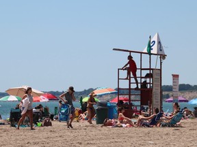 A lifeguard stands on guard while watching over a crowded Port Stanley beach on Friday. There is a minimum of eight to ten lifeguards on duty at any time at the Lake Erie beach. (SHANNON COULTER, The London Free Press)