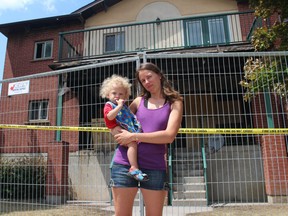 Eva Neudorf stands in front of her home with her one-year-old son Gavin. Her unit, as well as three others that are part of Tolpuddle Housing Co-op, were totally lost after a fire erupted Sunday night. A total of 12 families are currently displaced from the building. (SHALU MEHTA, The London Free Press)