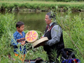 Mgiizi Wright and Chief Myeengun Henry play the the river song at the Chippewas of the Thames waterside pipe ceremony and renewal of vows at the Thames River in July last year. (London Free Press file photo)