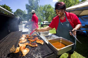 Rose Williams of Jamaica with her husband Erol Williams cooks some Jamaican jerk chicken at Sunfest on Friday July 6, 2018.  Mike Hensen/The London Free Press/Postmedia Network