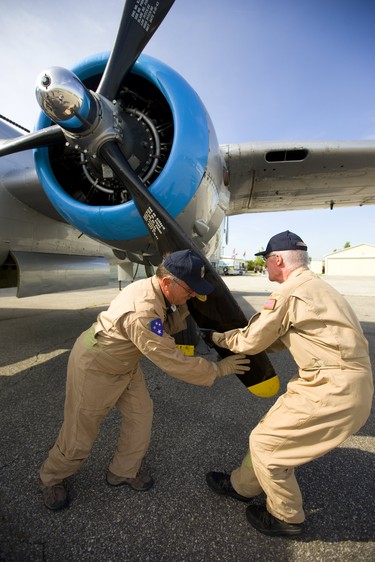 Pilot Richard Petty and crew chief Roland Smith rotate the huge propellers on a WWII Mitchell B-25 bomber to clear excess oil in the bottom cylinders of the massive radial engine. The bomber touched down at Sarnia Airport as part of a tour by the Commemorative Air Force on Thursday July 12, 2018. The B-25 was made famous by the Doolittle Raid, early in WWII after the U.S. was hit by the Japanese at Pearl Harbour, 16 B-25's launched off an aircraft carrier and bombed Tokyo and then ditched their planes in China. Mike Hensen/The London Free Press/Postmedia Network