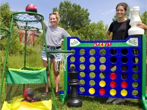 Emily Bradford and Sabrina Sater show off a few of the toys available at London city hall’s neighbourhood equipment library. (Mike Hensen/The London Free Press)