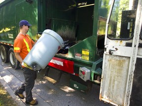 Greg Jordan of the City of London empties a garbage can in Oakridge. (Mike Hensen/The London Free Press)