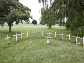 Crosses memorializing 13 people that have died at the Elgin Middlesex Detention Centre at the entrance to the facility on Exeter Road in London. (Derek Ruttan/The London Free Press)