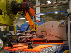 Robot 2 picks up 900 degree slabs of cut steel before they are hot pressed at quenched at Formet in St. Thomas. (MIKE HENSEN/The London Free Press)