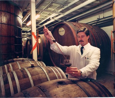 Peter A. Knowles draws a sample of red wine from an oak barrel at London Winery, 1988. (London Free Press files)