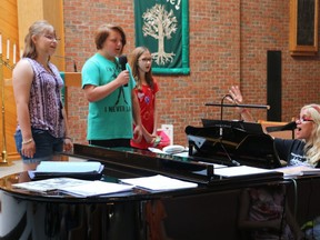 Campers Alex Fraser (left), Denver Milner and Emma (who asked the Free Press not to use her last name) rehearse the song "This is Me" with Allison O'Connor as she plays piano. O'Connor founded the Dreams Come True Music Studio. The studio's first summer camp session runs until Friday. (SHANNON COULTER, The London Free Press)