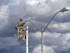 Craig Voorn and electrician with TM3, switches street lamp heads 18 meters above Commissioners Road at Wharncliffe Road in London, Ont. on Thursday March 17, 2016. The city is converting all of the incandescent lights to more efficient LED lights. (Free Press file photo)