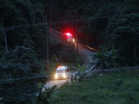Two ambulances with flashing lights leaves the cave rescue area in Mae Sai, Chiang Rai province, northern Thailand, Monday, July 9, 2018. The ambulance has left the cave complex area hours after the start of the second phase of an operation to rescue a youth soccer team trapped inside the cave for more than two weeks.