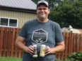 Michael Noltie, 31, owner and creator of Sod Buster Brewing Company of Dresden shows off two of his beers. Noltie's beer brewing days began at his home a couple of years ago, now his beer is available across the region.