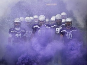 Offensive lineman David Brown, middle, running back Cedric Joseph, left, and linebacker Jean Gabriel Poulin, right, lead the Western Mustangs onto the field prior to their Vainer Cup football game victory over the Laval Rouge et Or in Hamilton, Ont., on Saturday, November 25, 2017.