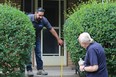 Brosco Concrete owner Marco Antolini makes some measurements on Robert Williams' front porch steps as Williams looks on. Williams and his 96-year-old mother will be receiving new steps for free after Canada Post sent a health and safety complaint to the home for having a top step that is too high.