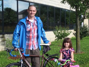 Local cyclist Andrew Hunniford and his six-year-old daughter Alice stand with their bikes in front of Earl Nichols Arena in South London. Hunniford has organized a bike ride for children and their parents through his neighbourhood to teach them about safe cycling and the pathways that connect neighbourhood landmarks. SHALU MEHTA/THE LONDON FREE PRESS