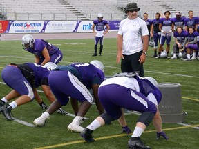 Western Mustang defensive coordinator Paul Gleason works with his players during practice at TD Stadium in this file photo.