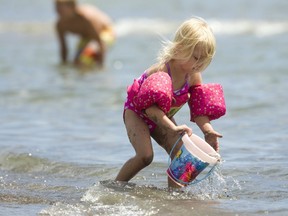 Peyton Knox, 3 of London kept busy on the beach in Port Stanley hauling buckets of water onto the beach to help craft her sandcastle. (Mike Hensen/The London Free Press)