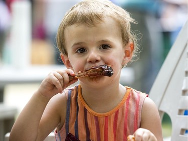 Elsie Tandecki, who said she is almost 3 years old, digs into a rib during the final day of London Ribfest on Monday August 6, 2018. The ribs were "a little bit spicy." She was at Ribfest with her father Marcin.  (Derek Ruttan/The London Free Press)